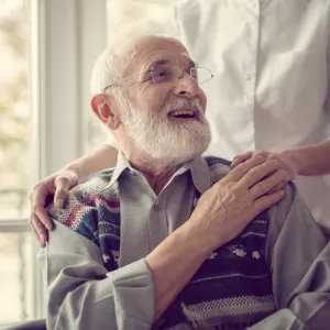 Oudere man met verpleegster hand op schouder