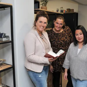 3 collega's die ADL-training volgen kijken naar camera