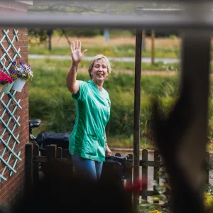 Elisabeth zwaait naar cliënt tijdens wijkzorg
