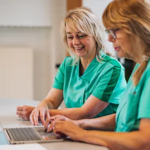 Collega Ingrid voor campagne Ontdek werken als Verzorgende IG bij ViVa! samen met een collega achter de laptop