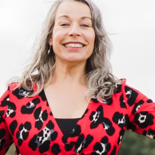 Portret van lachende vrouw in rood met zwart kledingpatroon bij ViVa! Zorggroep