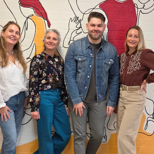 Team Recruitment poseert voor een gekleurde muur