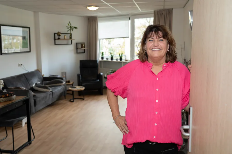 Medewerkster van Sint Agnes staat in deuropening