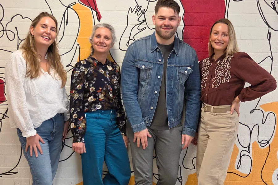 Team Recruitment poseert voor een gekleurde muur