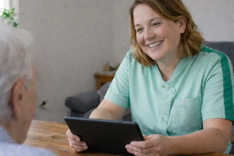 Coördinerend VIG met Ipad in gesprek met cliënt