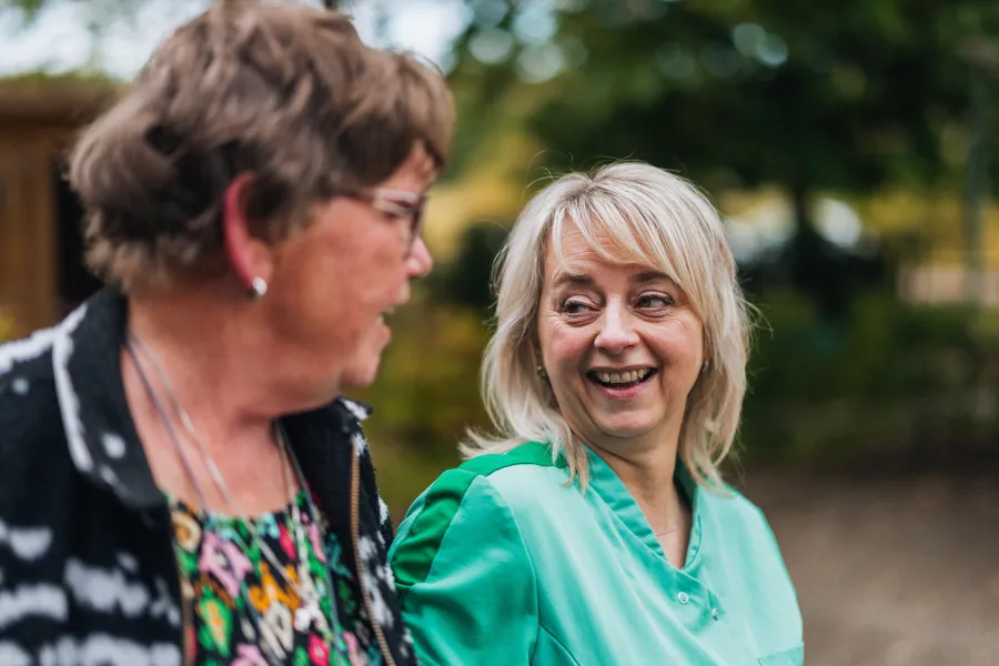 Ingrid lacht met cliënt tijdens wandeling