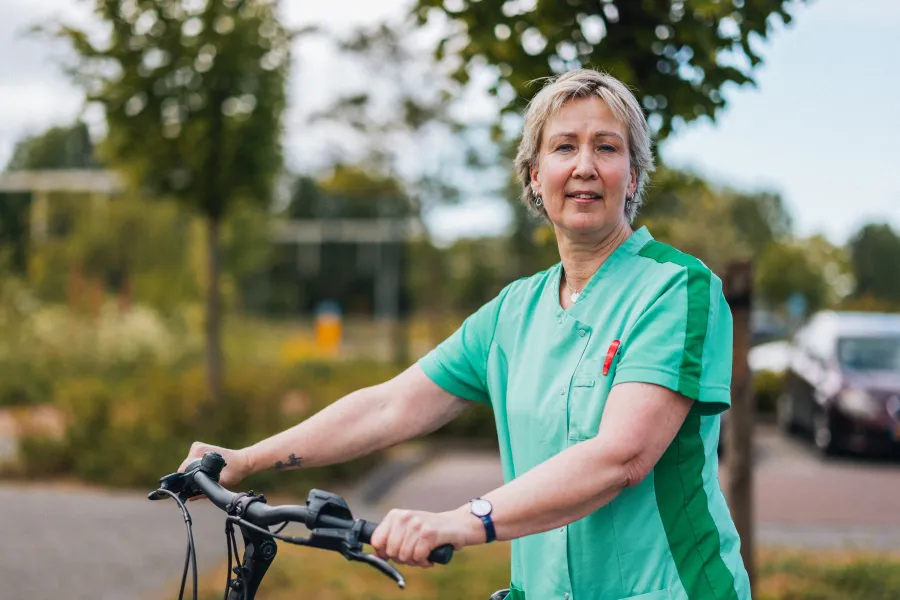 Elisabeth met fiets door de wijk voor wijkzorg