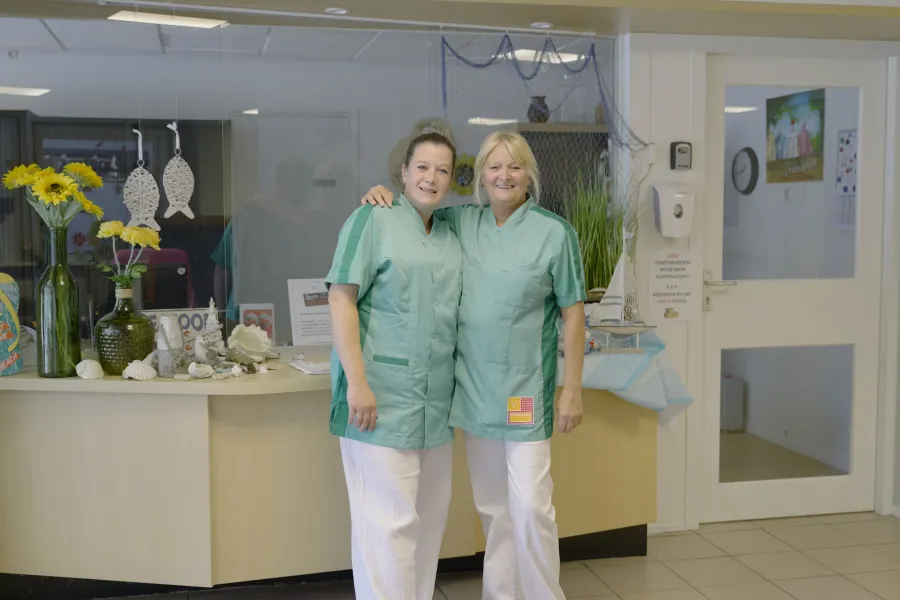 Mellanie en Gemma staan lachend voor de receptie van ViVa! De Santmark