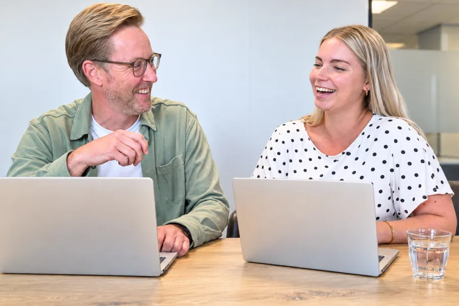 Op kantoor collega's in gesprek achter laptop